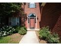 Inviting brick home entrance with arched doorway, manicured shrubs, and well-lit walkway at 12520 Vantage Point Ln, Huntersville, NC 28078