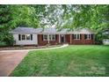 Lovely brick home with manicured lawn, charming entryway and mature trees giving ample shade at 1538 Hilltop Dr, Shelby, NC 28150