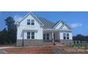 Newly built two-story home featuring a welcoming front porch and brick and siding exterior at 156 Triple Ponds Ct, Clover, SC 29710
