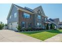 Gorgeous home with a three-car garage and a mix of brick and siding on the exterior at 19012 Beecher Commons Dr, Huntersville, NC 28078