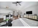Bright living room boasts a ceiling fan, modern decor and seamlessly connects to the kitchen at 228 Briana Marie Way, Indian Trail, NC 28079