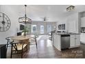 Open-concept living and dining area features hardwood floors, modern lighting, and stainless steel appliances at 228 Briana Marie Way, Indian Trail, NC 28079