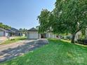 Traditional single-story home with a well-manicured lawn, mature trees, and an attached two-car garage at 2912 Peachwood Ct, Fort Mill, SC 29715