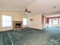 Spacious living room features a stone fireplace, a ceiling fan, and bright, natural light from several windows at 2912 Peachwood Ct, Fort Mill, SC 29715