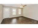 Bright living room featuring two windows, a ceiling fan, and a hardwood floor for a cozy and inviting atmosphere at 671 Sylvan Sw St, Concord, NC 28025