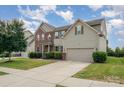 View of the house showcasing the driveway, landscaping and the combination of brick and light beige vinyl siding at 7362 Waterwheel Sw St, Concord, NC 28025