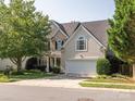 Traditional two-story home with a well-manicured lawn and a two-car attached garage at 13930 Daltrey Ln, Charlotte, NC 28277