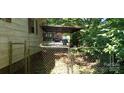 This carport is overgrown and has a chain-link fence at 202 N Dilling St, Kings Mountain, NC 28086