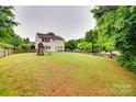 Expansive backyard featuring a well-maintained lawn, privacy fence, and a playset at 2103 Cantata Ct, Matthews, NC 28105