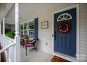 Inviting front porch features a blue front door adorned with wreath and charming porch decor at 317 Sugar Creek Xing, Fort Mill, SC 29715