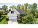 Charming home with a brick and white facade, complemented by a well-manicured lawn and a two-car garage at 3837 1St Street Nw Ln, Hickory, NC 28601