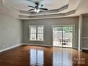 Living room featuring tray ceiling, hardwood floors, and a sliding glass door to the deck at 3837 1St Street Nw Ln, Hickory, NC 28601