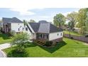 Beautiful home with lush green lawn, and a patio, surrounded by trees, offering privacy and curb appeal at 3837 1St Street Nw Ln, Hickory, NC 28601
