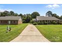Spacious property featuring a long driveway connecting a well-maintained home and a detached brick structure at 416 Park Ave, Granite Quarry, NC 28072