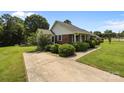 Brick home with mature landscaping, a concrete driveway, and a lush green lawn at 416 Park Ave, Granite Quarry, NC 28072