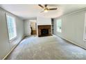 Inviting living room with a cozy fireplace, ceiling fan, and plush carpeting at 4832 Gideon Dr, Lincolnton, NC 28092