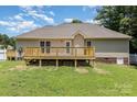 View of the back of the house with a spacious wooden deck and a well-maintained lawn at 608 Red Hawk Way, Clover, SC 29710