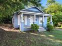 Charming single-story blue home featuring a covered porch, white columns, trimmed windows, and lovely curb appeal at 116 Honeywood Ave, Charlotte, NC 28216
