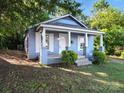 Inviting light blue single-story home with a covered porch, white columns, trimmed windows, and lovely curb appeal at 116 Honeywood Ave, Charlotte, NC 28216