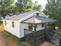 View of the home's rear exterior with porch, yard, and new roof at 1919 Gay St, Statesville, NC 28625