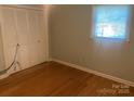 Bedroom with hardwood floors, window providing natural light, and built-in closet at 204 Biltmore Ave, China Grove, NC 28023