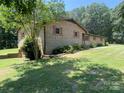 Brick home with tidy landscaping around its foundation and mature trees in the background at 204 Biltmore Ave, China Grove, NC 28023