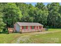 Charming single-story home with a spacious wooden deck and beautiful green yard at 2611 Dallas Stanley Hwy, Stanley, NC 28164