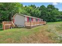 Charming single-story home with a spacious wooden deck and beautiful green yard at 2611 Dallas Stanley Hwy, Stanley, NC 28164