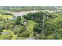 Aerial view of the home showcasing its beautiful lakeside setting, lush landscaping, and private driveway at 330 Waters Rd, Salisbury, NC 28146