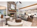 Comfortable living room with a stone fireplace, a gray sofa, and open access to the kitchen at 4033 Hilton Lake Rd, Kannapolis, NC 28083