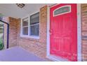 Inviting red front door with brick surround, offering a warm welcome to the home at 7753 Caswell Rd, Stanley, NC 28164