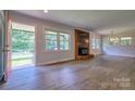 Open living room area with a brick fireplace and large windows providing natural light at 7753 Caswell Rd, Stanley, NC 28164
