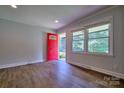 Bright entryway featuring new vinyl flooring, a red door, and freshly painted walls at 7753 Caswell Rd, Stanley, NC 28164