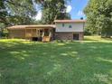 Expansive backyard featuring a brick exterior, a wooden deck, and a sliding door to indoor living spaces at 12003 Old Beatty Ford Rd, Rockwell, NC 28138