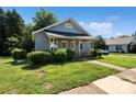 Charming single-story house featuring well-kept lawns, manicured shrubs, and a covered front porch at 404 Community St, Rock Hill, SC 29730