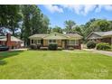 Well-maintained single-story home with a spacious front yard, mature trees, and inviting curb appeal at 5126 Unaka Ave, Charlotte, NC 28205