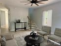 Bright living room featuring light grey walls, stairs, wood floors, and seating area near a window at 908 30Th Avenue Nw Dr # 2, Hickory, NC 28601