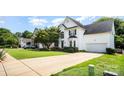 Beautiful two-story home with a well-maintained lawn and a long concrete driveway, with a partial view of a neighbor's home at 10230 Blackstock Rd, Huntersville, NC 28078