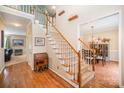 Inviting foyer with hardwood floors, a staircase, and view into dining room with chandelier at 10230 Blackstock Rd, Huntersville, NC 28078