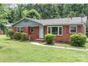 Charming single-story brick home with mature landscaping and a welcoming front porch, perfect for a cozy lifestyle at 1033 Rollingwood Dr, Charlotte, NC 28217