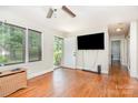Inviting living room boasts original hardwood floors, large windows, and is bathed in natural light, perfect for relaxing at 1033 Rollingwood Dr, Charlotte, NC 28217