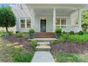 Inviting front porch with brick steps, white columns, and manicured landscaping at 17514 Harbor Walk Dr, Cornelius, NC 28031