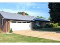 Traditional brick ranch home with a metal roof, attached garage, and long concrete driveway at 3080 Shue Rd, Salisbury, NC 28147