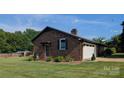 Brick ranch home showing a covered side entrance, a manicured lawn, and an attached garage at 3080 Shue Rd, Salisbury, NC 28147
