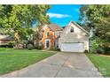 Lovely brick home boasts beautiful landscaping, an attached garage, and a welcoming driveway at 5015 Foxbriar Trl, Charlotte, NC 28269