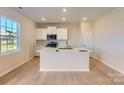 Bright kitchen with white cabinets, stainless steel appliances, and a large center island at 6391 Fairfax Ct, Maiden, NC 28650