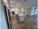 Spacious kitchen boasts stainless appliances, an island with sink, quartz counters, and access to the living area at 707 Marion Dr, Matthews, NC 28105