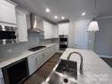 Modern kitchen featuring stainless steel appliances, a large island, and white cabinetry with a gas cooktop at 707 Marion Dr, Matthews, NC 28105