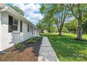 Charming single story home with a well manicured lawn, black shutters, and mature trees overhead at 104 Spargo St, Gastonia, NC 28056
