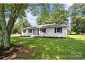 Charming single story home with a well manicured lawn, black shutters, and mature trees overhead at 104 Spargo St, Gastonia, NC 28056